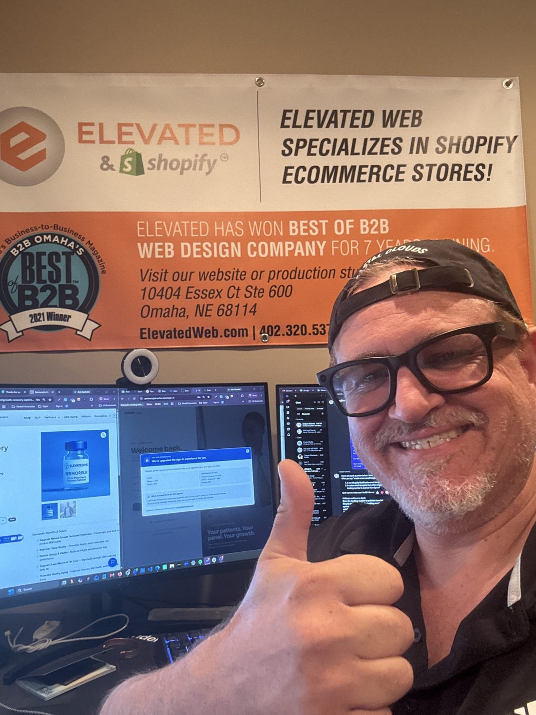 Andrew Boehm in the Elevated Web office in front of the Best of B2B banner