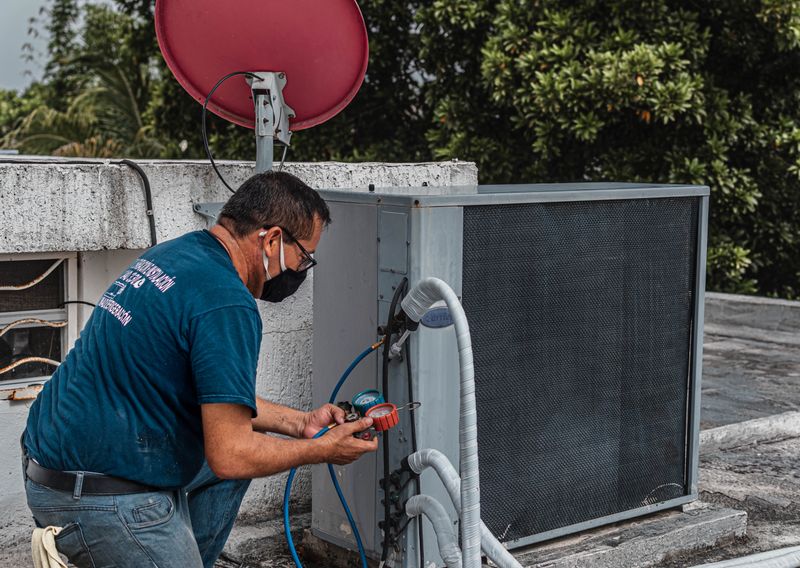 HVAC technician with gauges on an outdoor unit